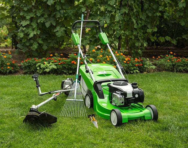 GrassNectar Lawn Care offers spring clean ups and fall clean ups for your yard - a green lawnmower, rake, and other lawn tools.